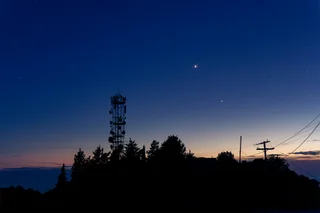 A telecoms tower silhouetted against a starry twilight sky, Greece